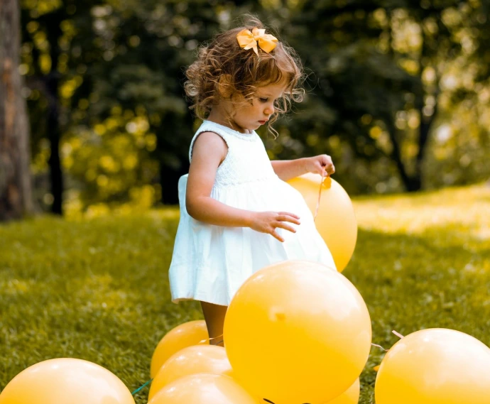 girl wearing white sleeveless dress beside balloons